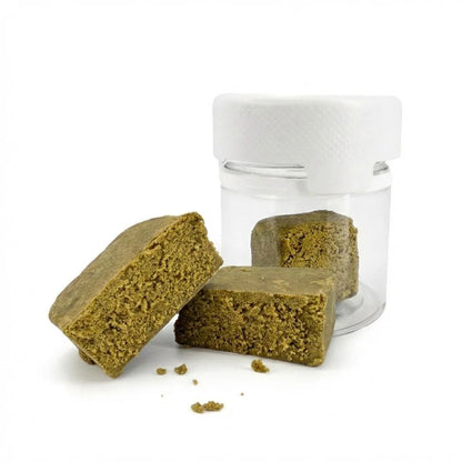 Golden Mousse 30% THCA HASH blocks with crumbly texture, placed beside a small clear jar with a white lid on a white background.